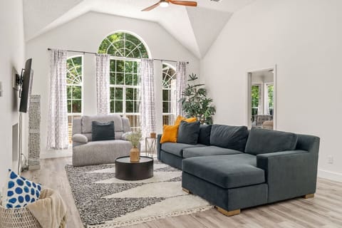Modern open-concept living area with a TV that includes all major streaming services,  plush seating and natural light.