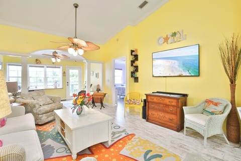 Relax in your bright, cheerful living room with comfy seating, coastal décor, and a flat-screen TV—perfect for unwinding after a day at the beach.
