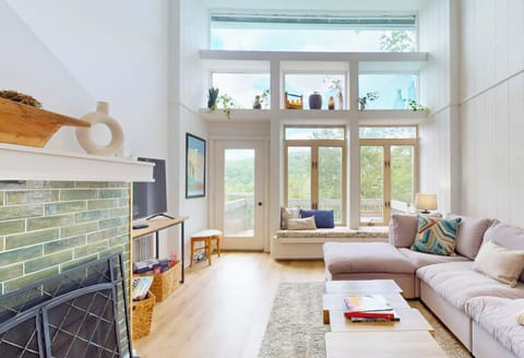 Sunlight pours through soaring windows, framing mountain vistas as you unwind on plush seating. The airy design invites peaceful moments and quiet connection in this serene, modern escape.
