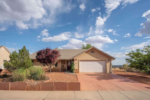 Charming single-story desert home featuring a spacious driveway and beautiful xeriscaping, perfect for a tranquil getaway.