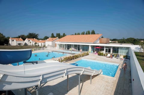 Aerial view of the outdoor pool area with the residence buildings and the Vendée sky in the background.