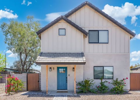 Modern exterior boasting a bold turquoise door and beautiful desert landscaping. 