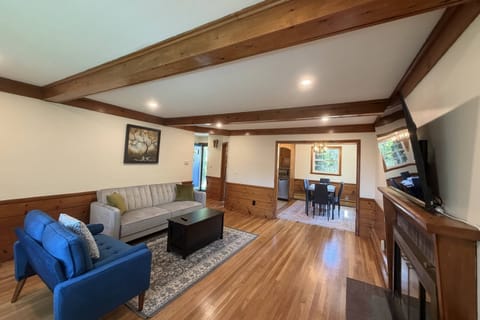 Living Room with plenty of seating and smart TV, view into the dining room