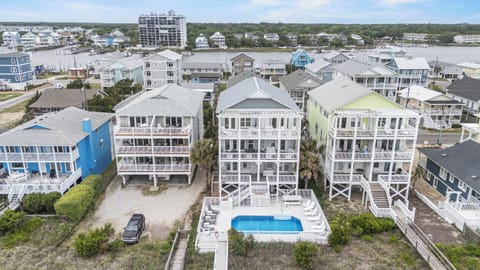 Elevated view of the vacation property showing its prime waterfront location, private pool, and proximity to the marina and surrounding coastal community.
