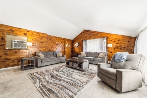 Gather with family and friends in the spacious living area featuring comfortable seating and soaring wood-accented ceilings.