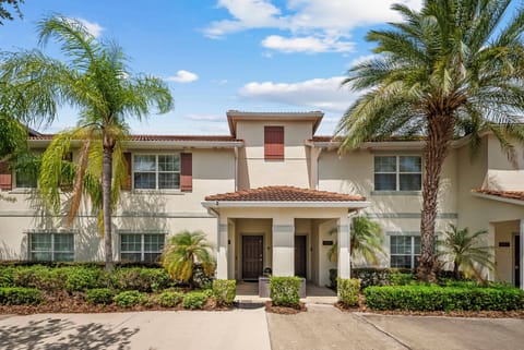 Step into a charming exterior framed by lush palm trees and vibrant greenery. The inviting entrance, highlighted by warm earth tones and a tiled roof, sets a welcoming tone for your stay, perfect for enjoying the sunshine.