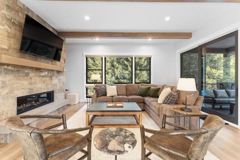 The spacious living room features a gas fireplace, 65 inch smart TV & sectional