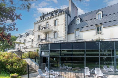 Floor-to-ceiling glass connects the heated indoor pool to the green parkland outside — swimming whatever the weather.