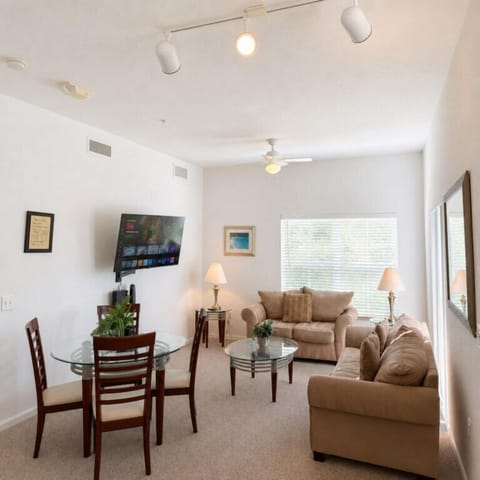 Cozy living room with plush sofas, smart TV, and natural light for relaxing evenings.