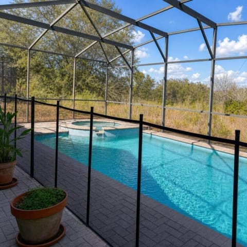 Private screened pool with safety fence, perfect for relaxing family afternoons.