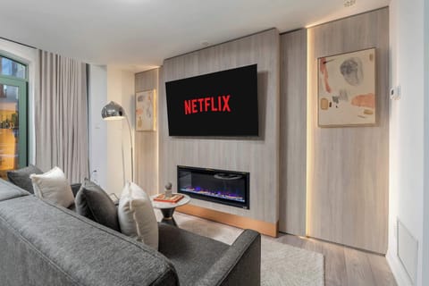Open-concept living and dining area with Smart TV, fireplace, and modern kitchen