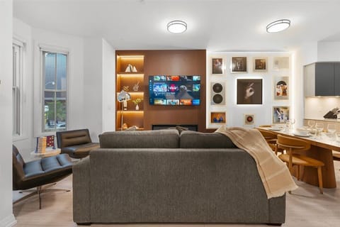 Modern living room with cozy seating, Smart TV, and sleek fireplace ambiance