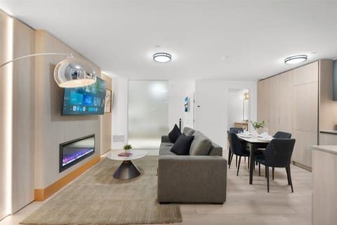 Open-concept living and dining area with Smart TV, fireplace, and modern kitchen