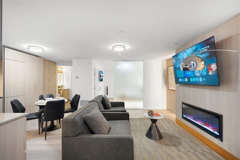Open-concept living and dining area with Smart TV, fireplace, and modern kitchen