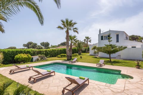 Vista general de la propiedad con piscina, jardín y fachada mediterránea