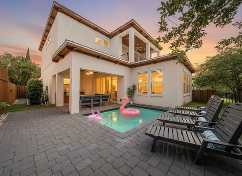 End your beach days here — the heated pool glows at dusk, flamingo floaties are waiting, and the outdoor kitchen is steps away. This is what vacation looks like.