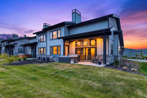 Twilight patio with a private hot tub, Adirondack seating, and sweeping mountain views.