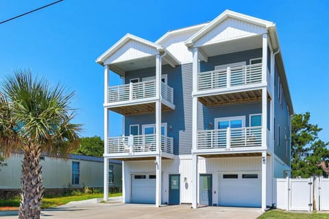 Modern duplex vacation rental featuring covered balconies and garage parking, located in a peaceful residential setting near coastal attractions.