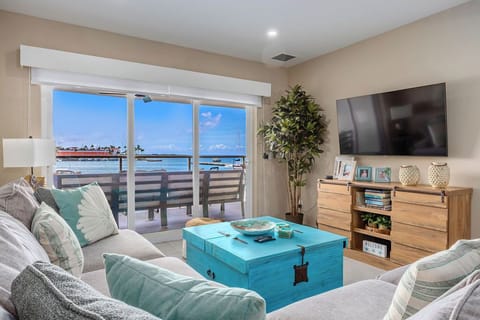 Sink into plush sofas as gentle sea breezes flow through your balcony doors, framing stunning water views. Your coastal retreat awaits with coastal-chic décor and endless relaxation.