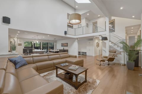 Spacious, upscale living space with soaring ceilings, smart TV, and fireplace