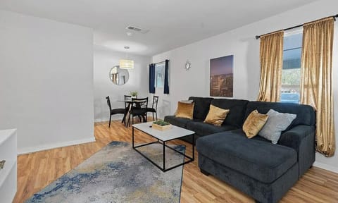 A comfortable setup featuring a dark gray sectional sofa, gold accent pillows, a