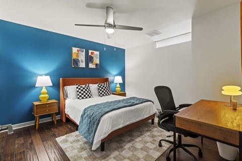 A cozy bedroom designed for both rest and productivity, featuring a comfortable bed and dedicated workspace for remote work or planning your day.