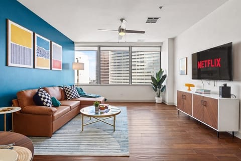 Kick back in this bright living room with cozy seating, a large TV, and wide windows that bring the city right into your stay.