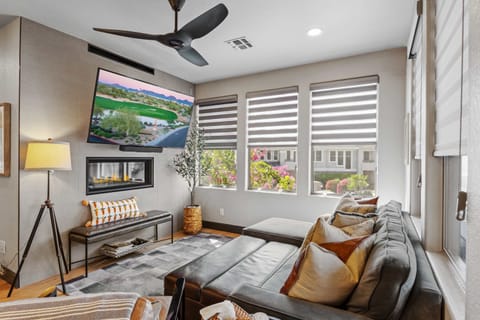 Relax in this bright, stylish living area with a plush sectional, cozy fireplace, oversized TV, and sun-filled windows.