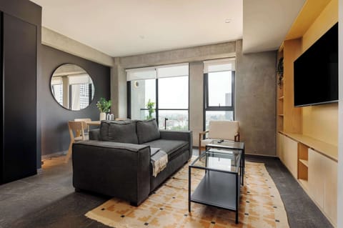 Bright living room with Smart TV and city views.
