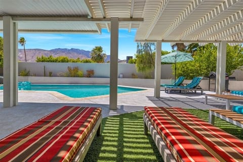 Covered patio retreat with pool, mountain views, and lounge chairs