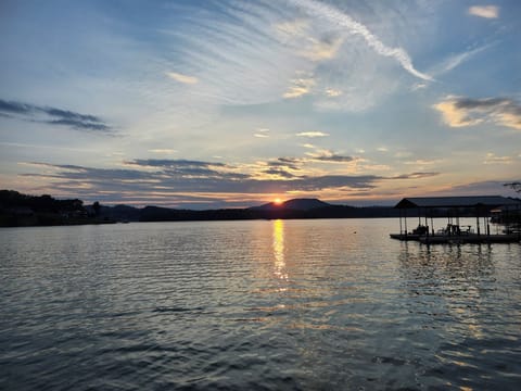 Sunset view of 1 slip covered dock and deck for fishing swimming boating