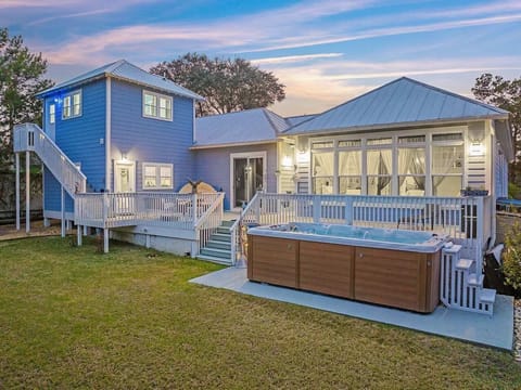Unwind in style! This beautiful coastal retreat features a massive multi-level deck and a luxurious swim spa/hot tub, all set against a stunning sunset backdrop. Your ultimate relaxation destination.