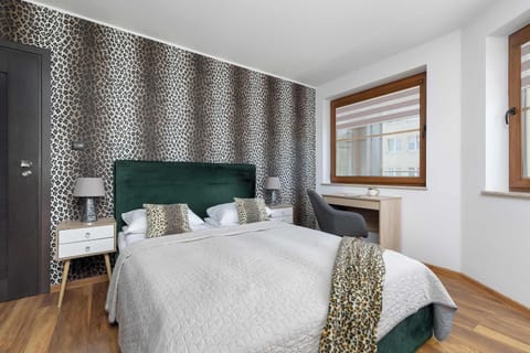 Elegant bedroom with upholstered bed, patterned wallpaper and natural daylight