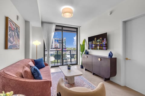 Elegant living room with plush pink velvet seating, curated art gallery wall, Smart TV and designer coffee table — sophisticated and inviting