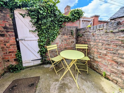 Charming brick courtyard with bistro seating and ivy-covered gate