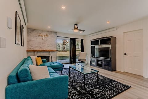 Open living room with teal sectional and fireplace