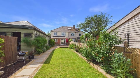 Landscaped garden with outdoor dining area and BBQ  