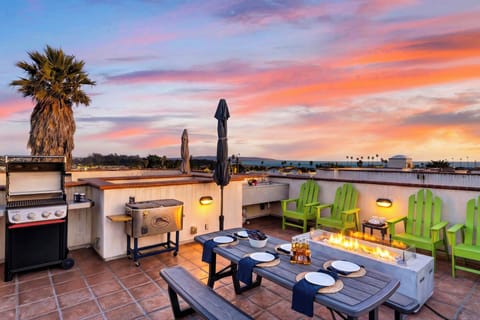 Experience unforgettable golden hour sunsets from your massive private rooftop deck, complete with a cozy fire table and dining setup.