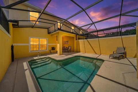 Private screened pool area with evening lighting and outdoor seating.