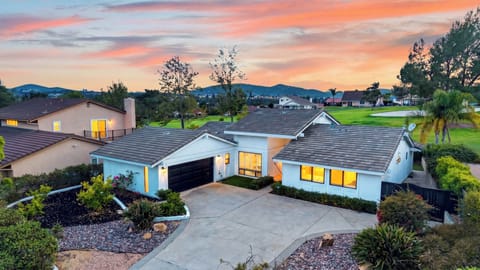 A gorgeous twilight shot showcasing the home’s welcoming exterior lighting, concrete driveway, and flawless landscaping.