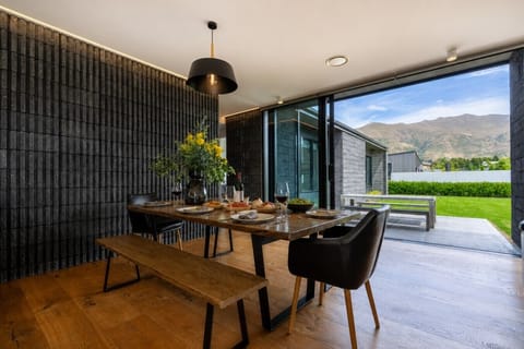 Gather around your live-edge dining table with mountain views stretching beyond the glass doors to your private lawn