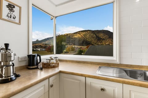Coffee station and kitchen bench bathed in natural light with mountain views