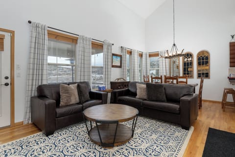 Sink into plush leather sofas in your open living space, where large windows frame mountain views and cozy details invite relaxation.