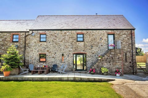 Stone cottage with patio seating and lawn in front