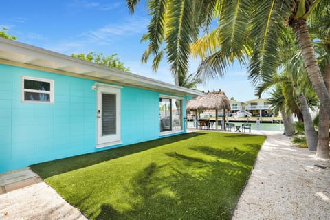 The palm-lined turf yard offers a low-maintenance outdoor space for relaxing by the canal at this pet-friendly Key Colony Beach vacation rental.