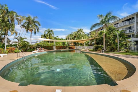 Sunny afternoons are well spent around this shared pool, where tropical landscaping and shaded areas create a welcoming resort-style atmosphere.