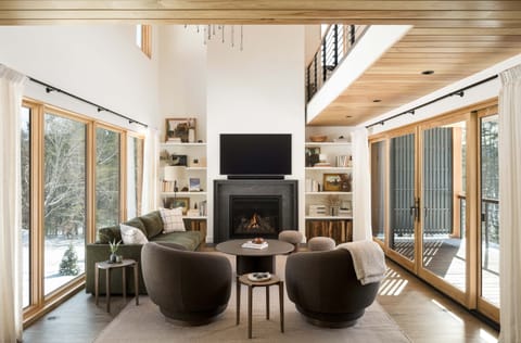 Beautiful family room complete with large smart TV, fireplace, comfortable seating, and large, open windows.
"Select photography by Ryan Bent Photography"