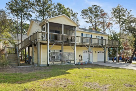 A charming elevated beach house nestled among mature trees, offering covered parking and easy access to your coastal retreat.