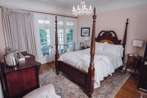 Elegant four-poster bedroom with French doors and charming classic details