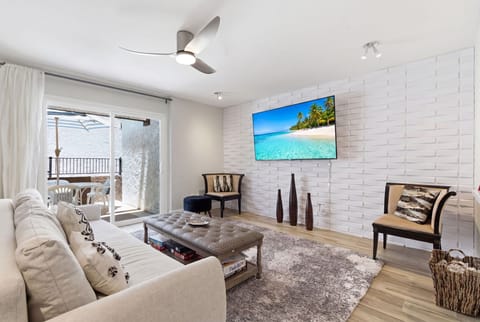 Chic living room with a comfy sofa that doubles as a sleeper, Smart TV, board games, and private patio access for easy indoor-outdoor relaxation.